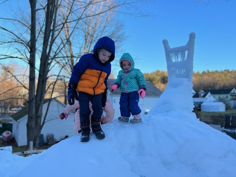 kids playing in snow pile