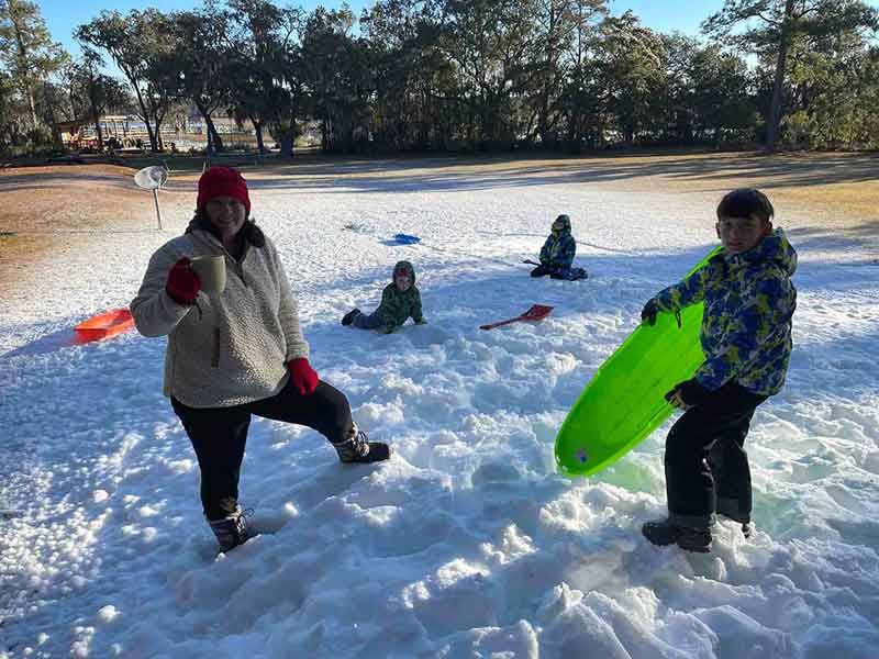 Family Sledding with snow made from Backyard Snowstorm Snow-gun